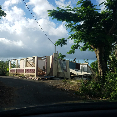 A home with few walls left standing on a hill after Hurricane Maria hit Puerto Rico.