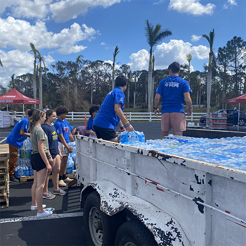 Volunteers unload huge trailer full of donated water.