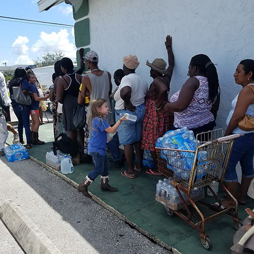 People in line for food and donations at distribution center at a church.