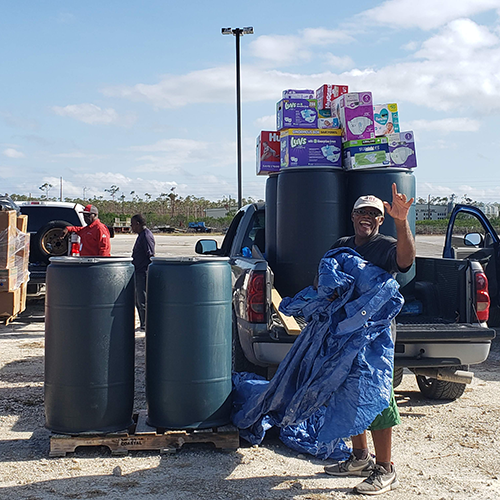 Man waves after receiving donations he had been waiting on for months in the aftermath of a hurricane.