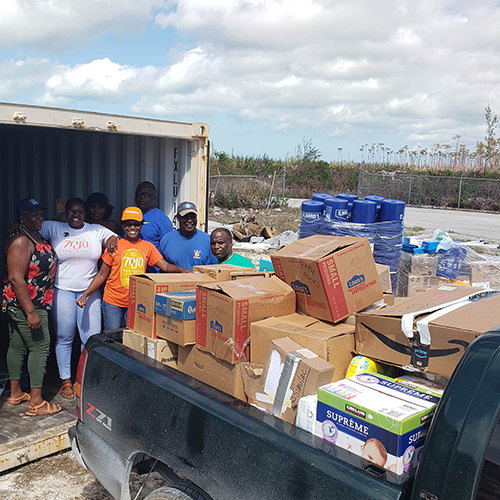 Volunteers unload containers of donations and supplies shipped to the Bahamas during hurricane relief efforts in Freeport.