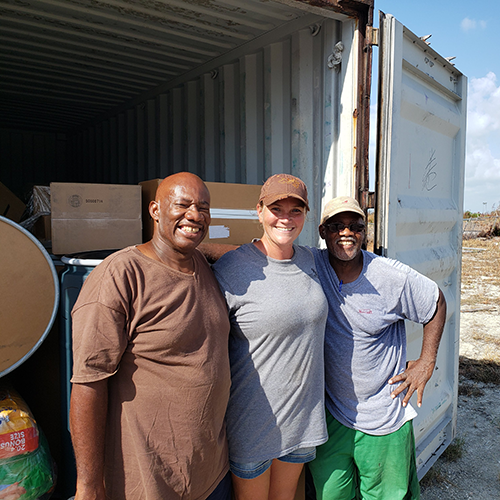 Smiling pastors and volunteers stand in front of donations loaded in a container sent from Florida to the Bahamas after Hurricane Dorian.