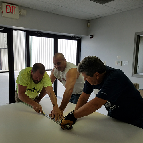 Men cut drywall to install in church that had flooded.