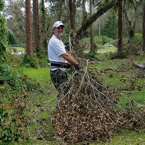 Volunteer working on debris removal from elderly widow's yard.