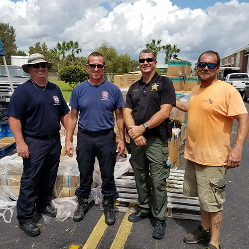 Volunteer with local law enforcement a distribution center after hurricane.