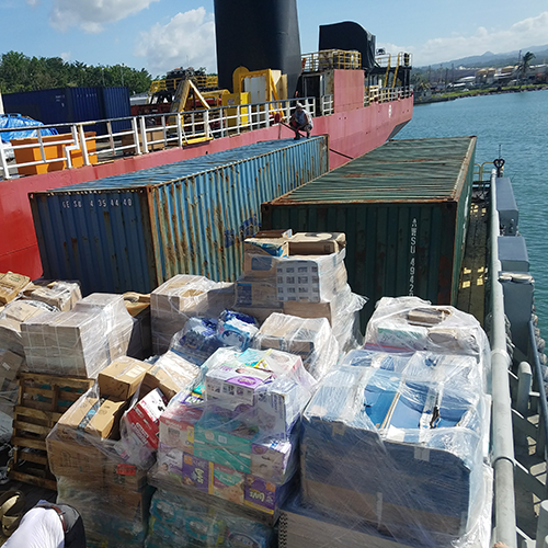 Shipping boat loaded with containers and pallets of donations, supplies, solar panels, and more for the disaster relief efforts in Puerto Rico after Hurricane Maria.