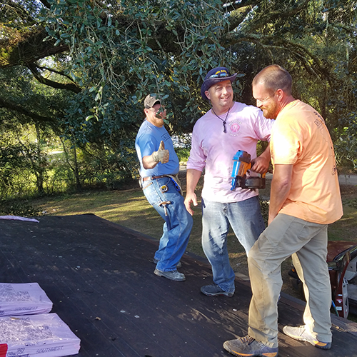 Men working on replacing a roof.