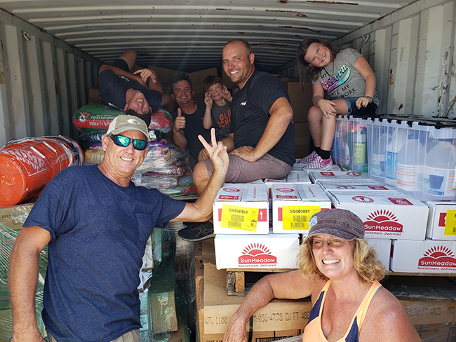 Volunteers from SOL Relief and the GSSM kids smile in front of a shipping container packed with donations for the Bahamas after Hurricane Dorian.