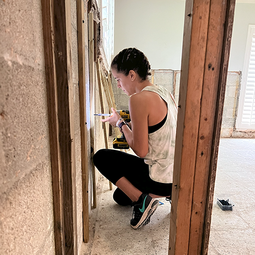 Volunteer works on prepping to hang replacement drywall in home that flooded during a storm.